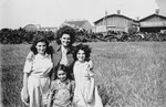 A female counselor poses with three girls in the Rosenheim displaced persons' camp.