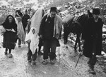 A group of refugees carry their belongings on a snowy path in Croatia.