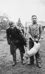 Two German Jews who are living in the Gross Breesen vocational center pose for a photograph with a piglet.