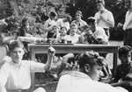 Jewish youth eat sandwiches outdoors at the Gross Breesen agricultrual training center.