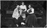 Three Jewish women pose on a park bench in Pruzhany.