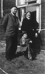 Kurt and Else Stein pose with their son, Werner, who is riding a tricycle.