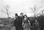Jan Yoors (center) poses with arms around Romani friends, as a child looks on.