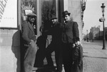 Three Romani men and a young boy stand outside the front door of a bar in Brussels.