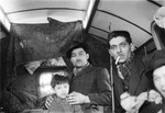 A Romani family is seated inside their caravan.
