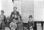 A group of Romani children pose for a photograph, with Jan Yoors in center back.