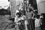 A Romani family poses around the doorway of their caravan with Jan Yoors (left, back).