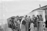 A group of Roma gathers around a couple during a celebration (possibly a wedding).