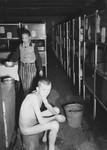 Close-up of two survivors, one naked, in an infirmary barracks of the Dachau concentration camp.