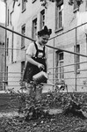A young girl waters her garden in the Stuttgart displaced person's camp.