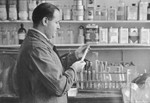 Alfred Nadelmann examines a test tube in his pharmacy, the Hof und Garnison-Apotheke in Stettin.
