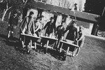 A group of children pushes wheelbarrows on the grounds of the Masgelier children's home in France.