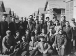 Group portrait of male prisoners in front of the barracks of the Beaune-la-Rolande internment camp.
