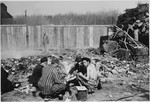 Survivors cook on scrap heaps to try to obtain some nourishment, three days after liberation.