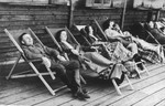 SS officer Karl Hoecker and some women relax on lounge chairs on a deck in Solahuette.