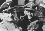 Commandant Richard Baer (right) accompanies Oswald Pohl (left) during an official visit to Auschwitz by automobile.