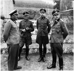 Group portrait of four SS officers at the Gross-Rosen concentration camp.