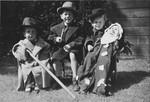 Group portrait of a three Jewish Dutch children wearing costumes.