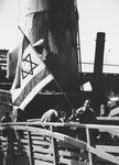 Young Holocaust survivors carrying a Zionist flag walk up the gangway to the Mataroa en route to Palestine.
