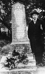 Moise Ginzburg stands next to the grave of his father and uncle, Binyamin and Shlomo Ginzburg, who were killed by bandits on a highway.