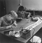 Two boys work on an art project in a classroom of an unidentified OSE post-war children's home.