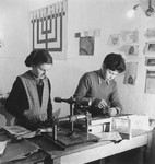 A boy and a girl make linoleum print greeting cards in an unidentified post-war OSE children's home.