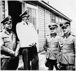Four SS men stand outside a building in the Gross Rosen concentration camp.