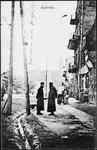 Jewish men stand on a commercial street of prewar Bialystok.