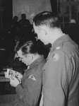 Capt. John Barnett authenticates photos taken when his troops overran the Dachau concentration camp during the trial of former Dachau camp personnel and prisoners.