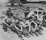 Newly liberated British POWs sit on the grounds of Stalag XIB [Eleven B], a camp outside Fallingbostel.