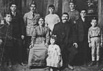 Studio portrait of a large family of Greek Jews from Ioannina discovered crumpled on the floor of their ransacked home after the war.