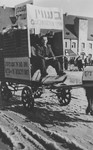 A Jewish DP drives a horse drawn float through Landsberg decorated with signs denouncing Ernest Bevin and calling for greater immigration to Palestine.