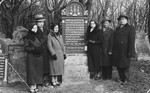 A Polish-Jewish family poses by the grave of its mother.