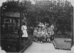German kindergarteners pose for a class portrait in a garden.