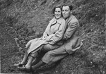 Close-up portrait of a German-Jewish couple sitting on a hillside.