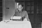 A SS officer [perhaps Max Schmidt] works at his typewriter.