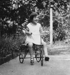 Lore Rothheimer rides her bicycle through a garden.