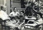 Isaak Krzywanowski sits on a porch with his wife and children.