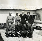 A group of men pose outside a building in Ferramonti.