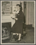 Portrait of Martha Sharp standing next to a fireplace.